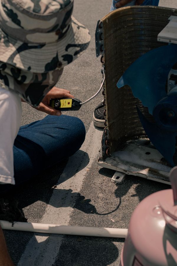 HVAC technicians installing equipment at a condenser unit