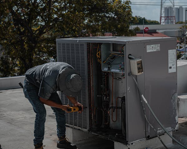 HVAC technician using tools on system components